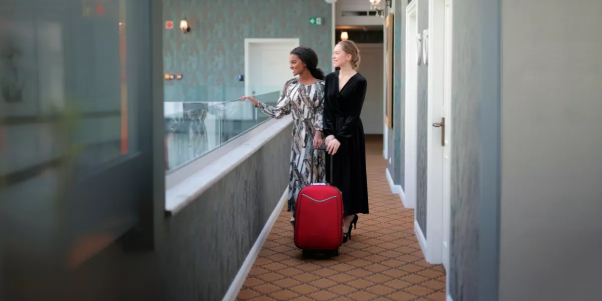 Dos-mujeres-sofisticadas-con-una-maleta-roja-en-un-hotel-moderno