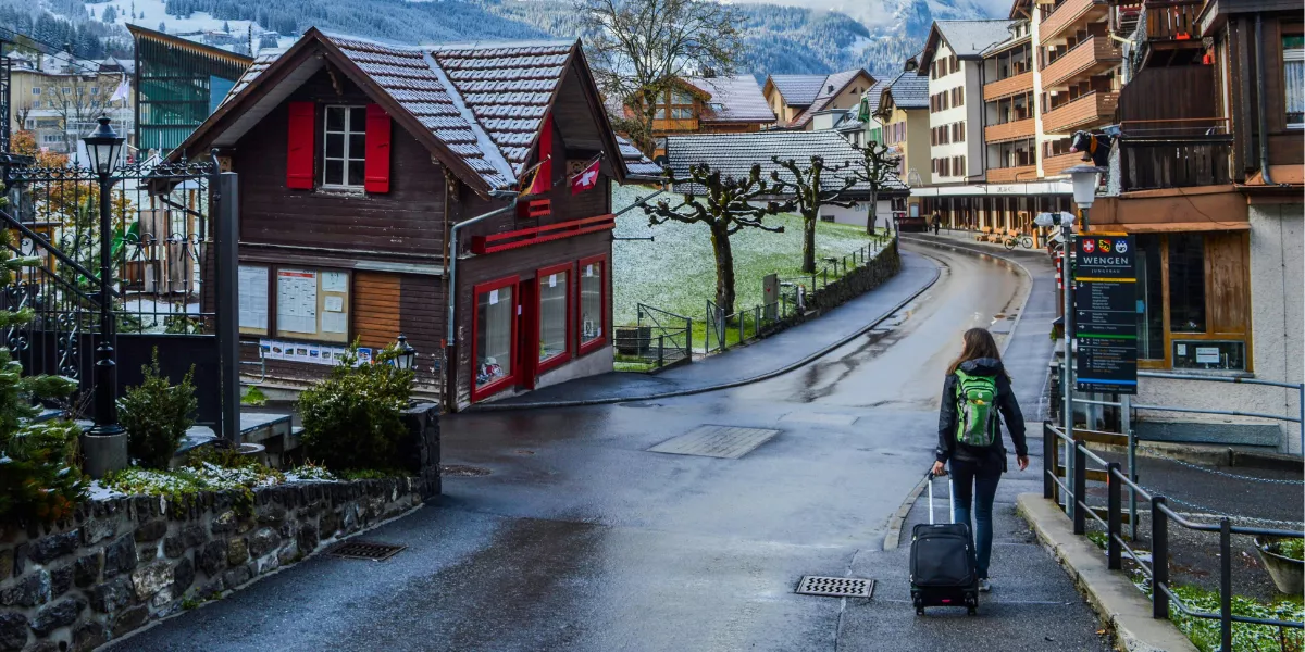 Mujer-caminando-por-pueblo-rural-cerca-de-montanas-nevadas