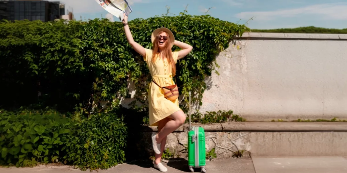 Mujer-con-vestido-amarillo-maleta-verde-en-un-dia-soleado